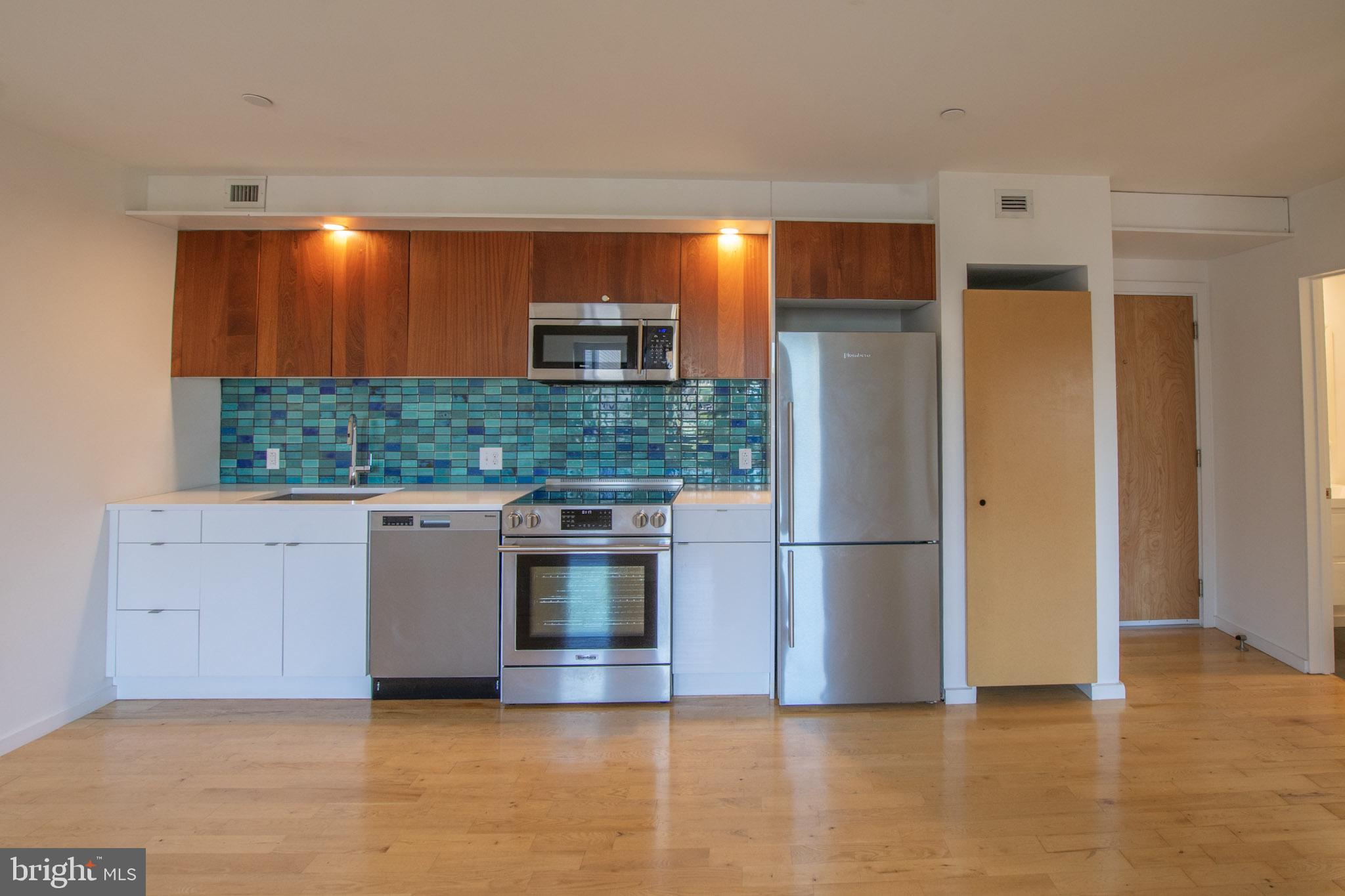 152 West Laurel Street, Unit 303 Philadelphia, PA 19123 - Photo 8 of 36 a kitchen with stainless steel appliances granite countertop a refrigerator a sink and a stove