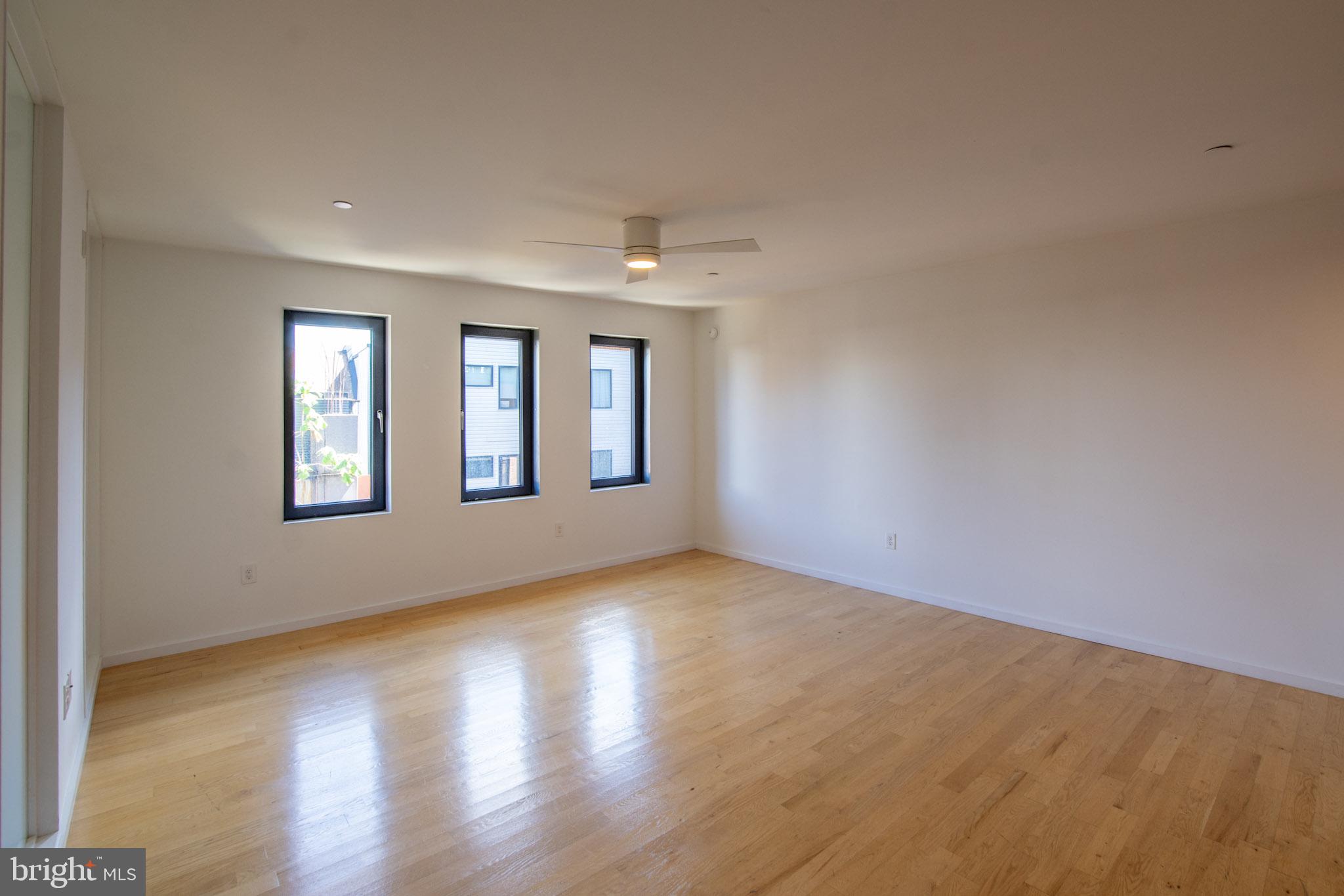 152 West Laurel Street, Unit 303 Philadelphia, PA 19123 - Photo 10 of 36 a view of an empty room with wooden floor and a window