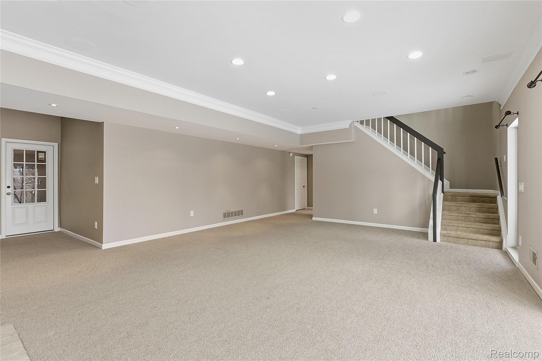 7154 Westchester Road West Bloomfield, MI 48322 - Photo 4 of 38 Unfurnished living room featuring stairway, recessed lighting, light colored carpet, and crown molding