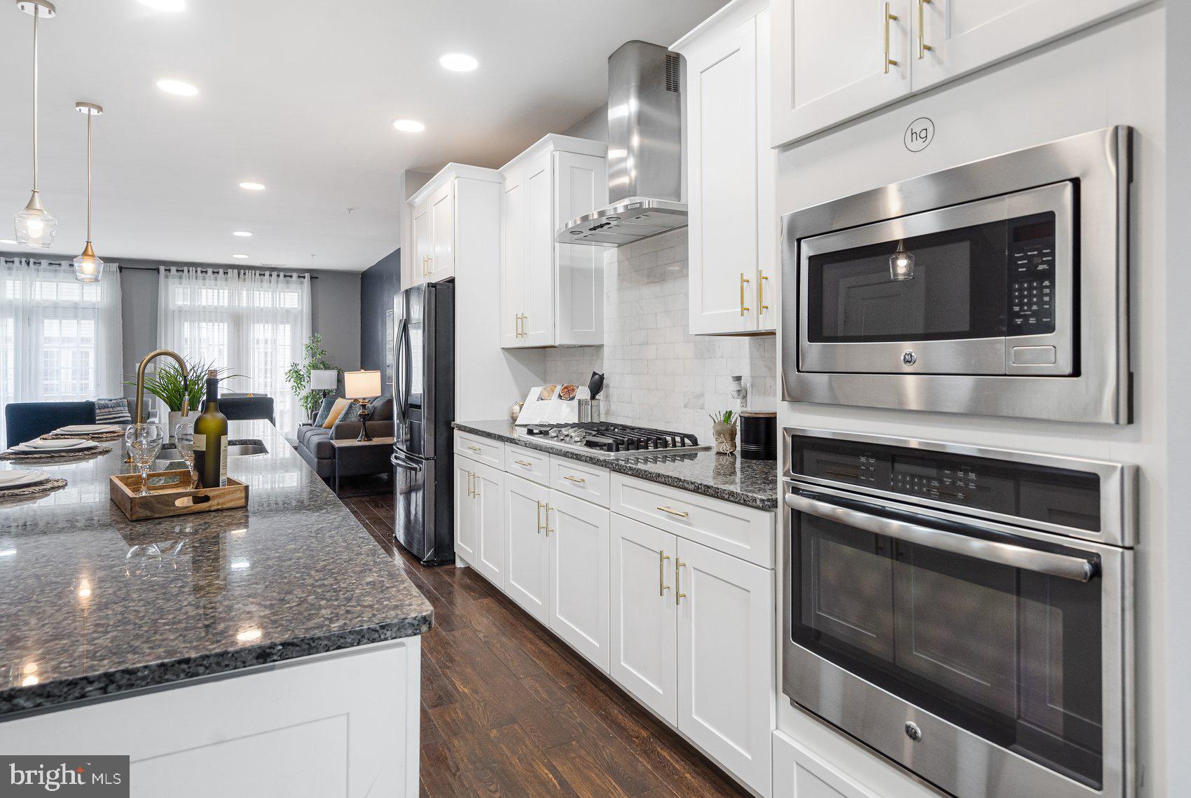 7429 Matapan Drive Hanover, MD 21076 - Photo 13 of 37 a kitchen with stainless steel appliances kitchen island granite countertop a stove and a sink