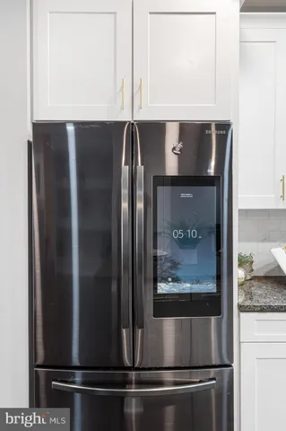 a kitchen with stainless steel appliances granite countertop a sink a stove and white cabinets
