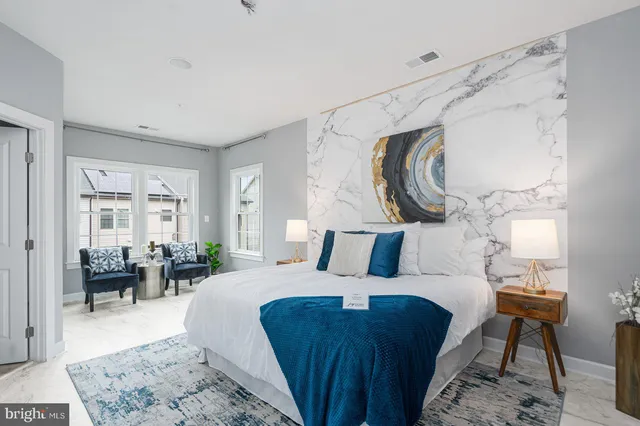 a bedroom with a large bed and a painting on the wall