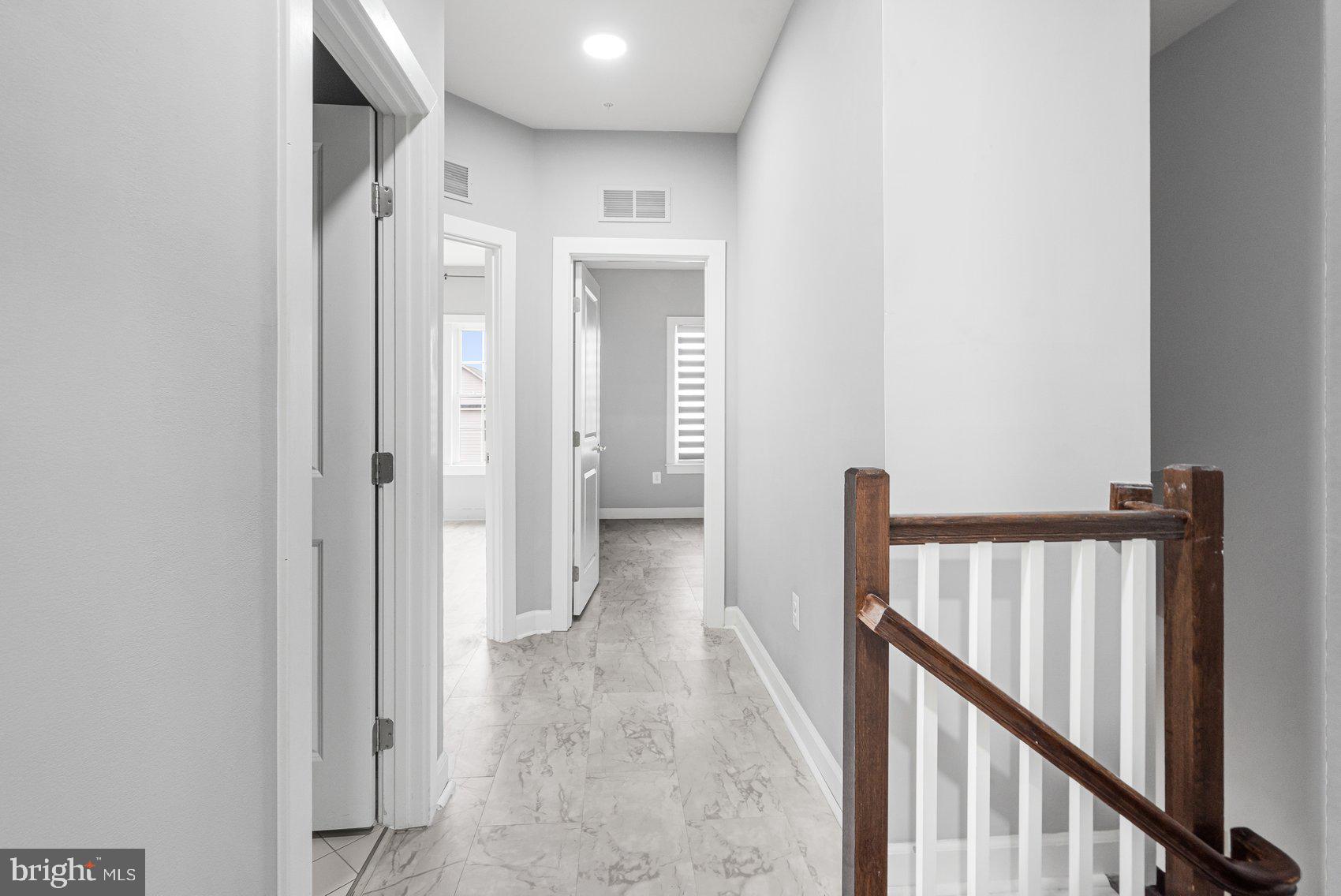 7429 Matapan Drive Hanover, MD 21076 - Photo 31 of 37 a view of a hallway with wooden floor and staircase
