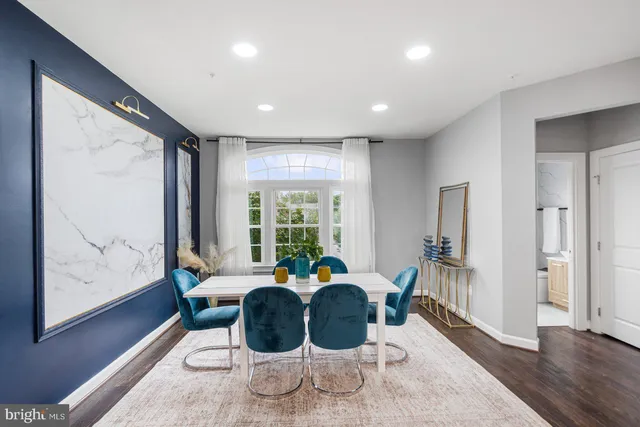 a living room with furniture large window and wooden floor