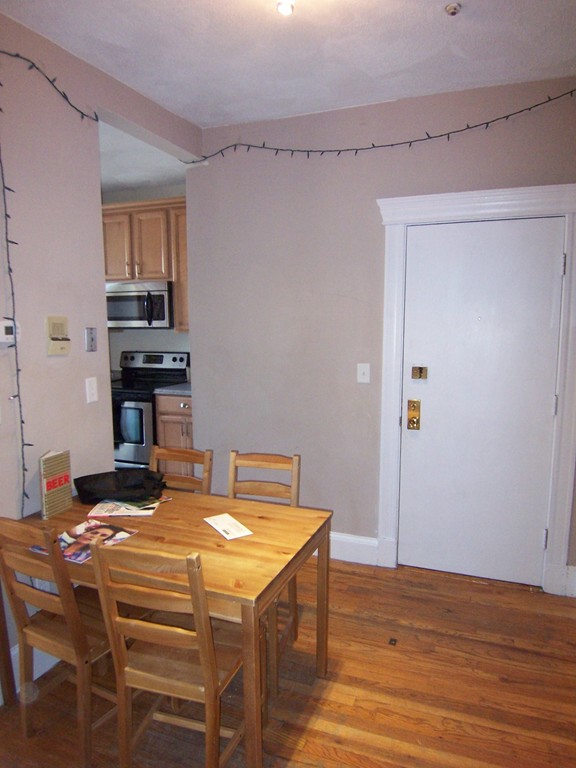 61 Park Drive, Unit 6 Boston, MA 02215 - Photo 3 of 7 a kitchen with a table chairs and a refrigerator