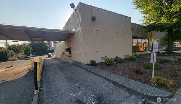 a view of a patio with table and chairs under an umbrella with a small garden