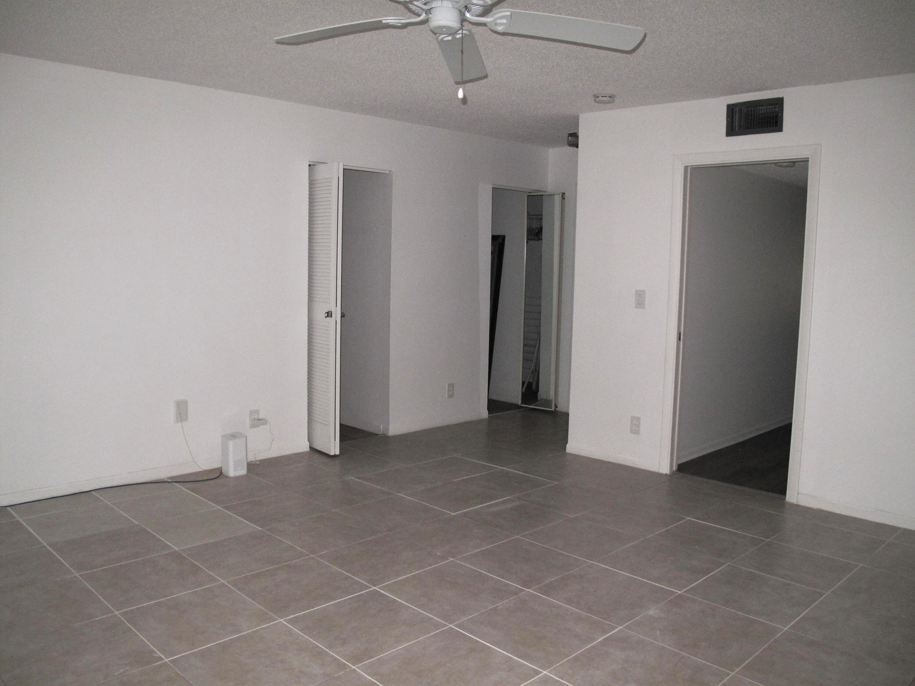 1162 Circle Drive, Unit B Delray Beach, FL 33445 - Photo 12 of 31 a view of an empty room with a ceiling fan