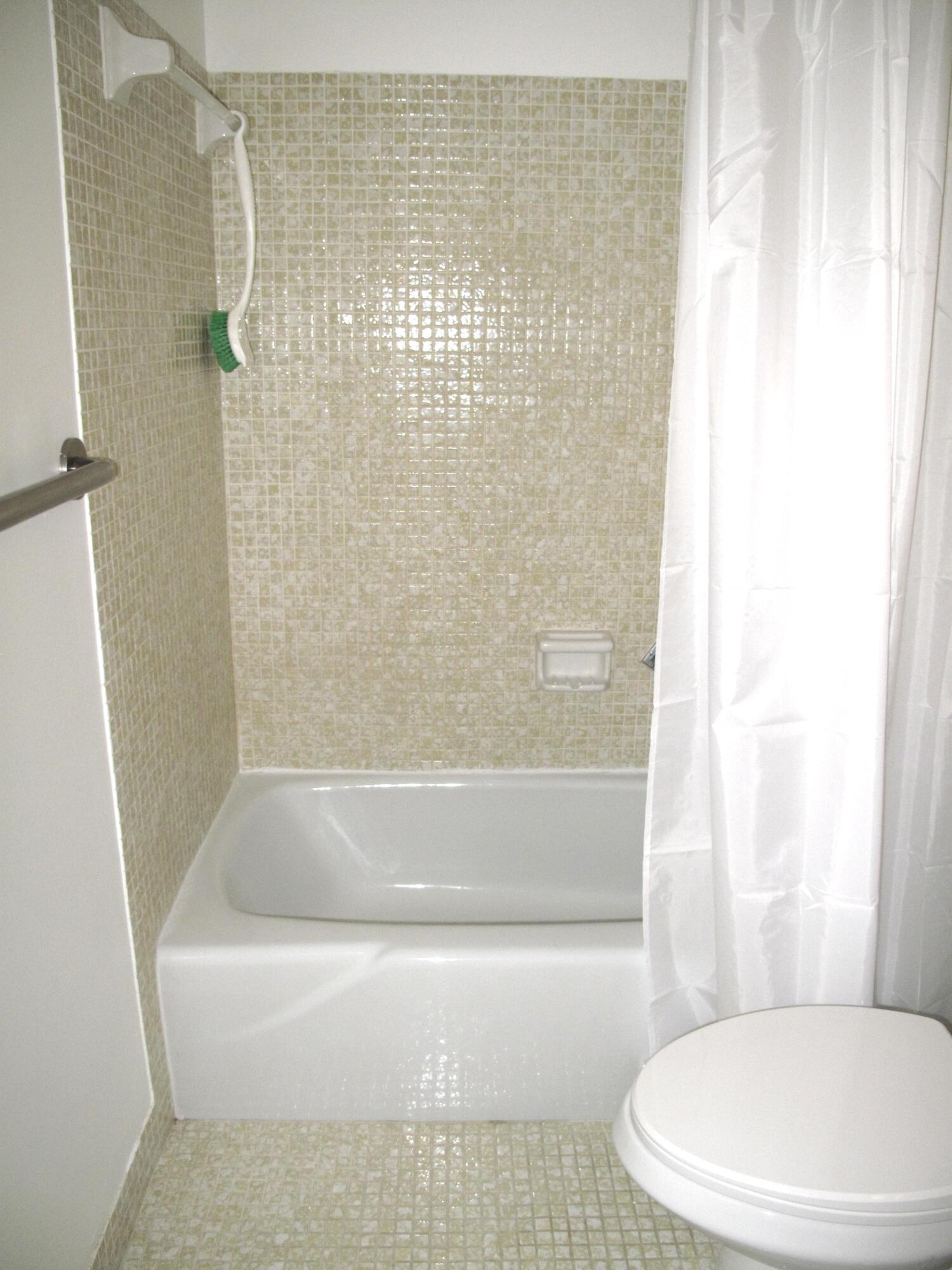 1162 Circle Drive, Unit B Delray Beach, FL 33445 - Photo 16 of 31 a white bath tub sitting next to a white toilet