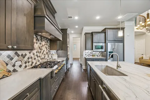 a kitchen with stainless steel appliances a sink stove and cabinets
