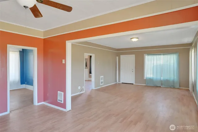 a view of a livingroom with wooden floor and a ceiling fan
