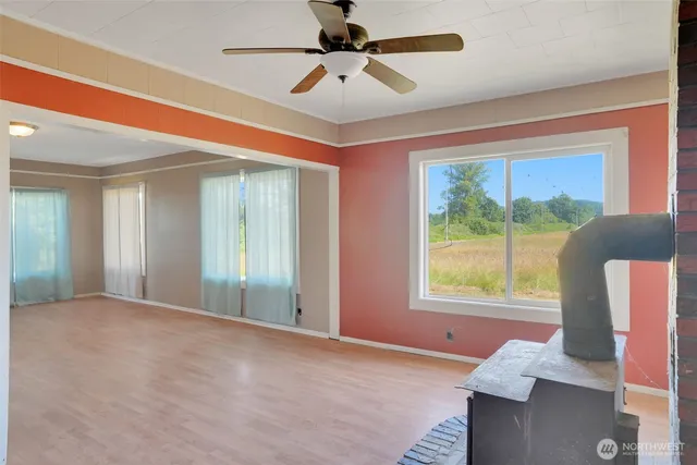 a view of an empty room with a window and a ceiling fan