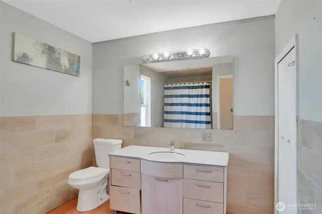 a bathroom with a toilet sink and mirror