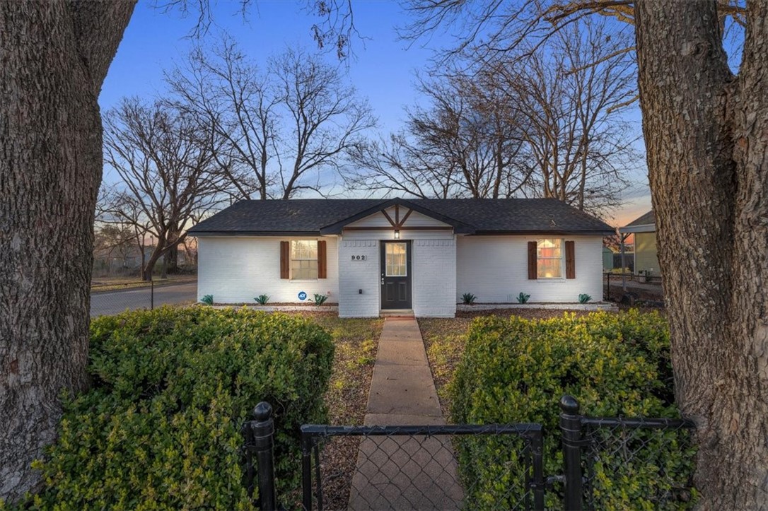 a front view of house with yard and trees in the background