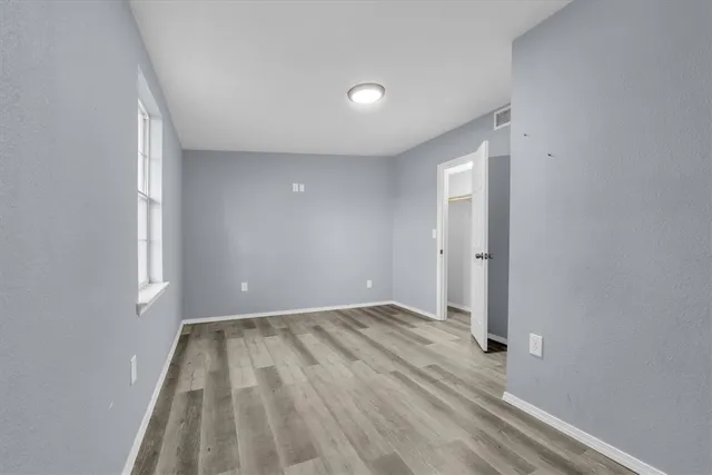 wooden floor in an empty room with a window