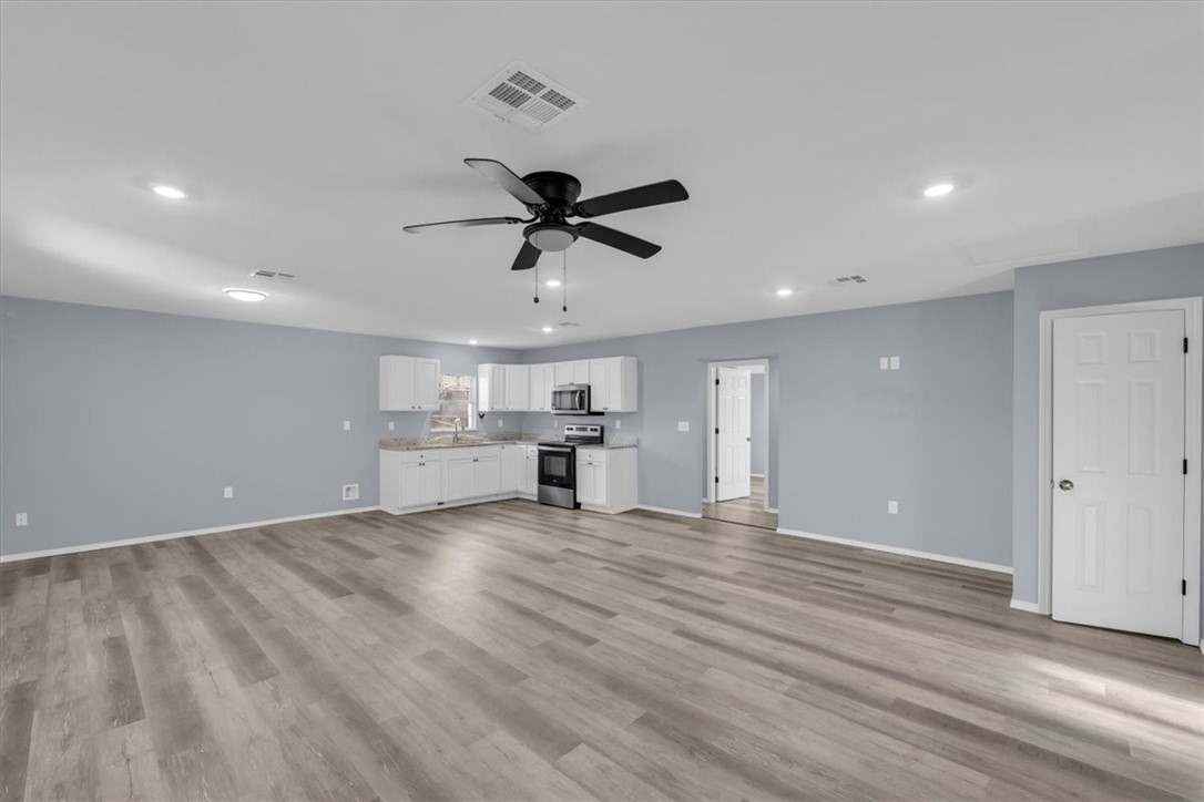 902 Calumet Avenue Waco, TX 76704 - Photo 7 of 27 a view of a kitchen with wooden floor and a ceiling fan