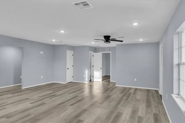 a view of an empty room with wooden floor
