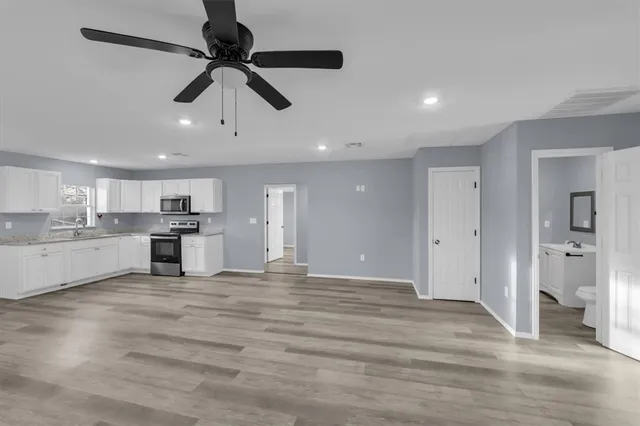 a view of a kitchen with a sink stainless steel appliances and cabinets