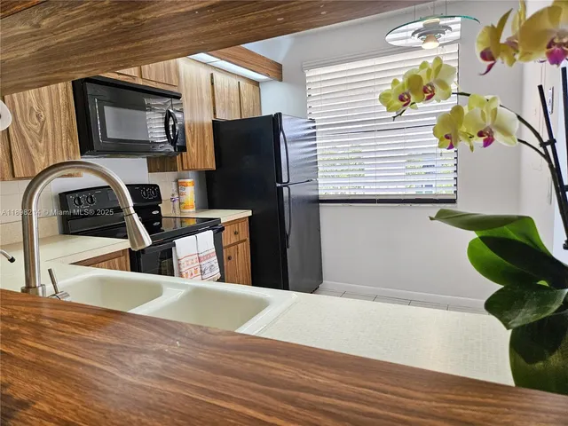 a view of a kitchen filled with furniture and natural light