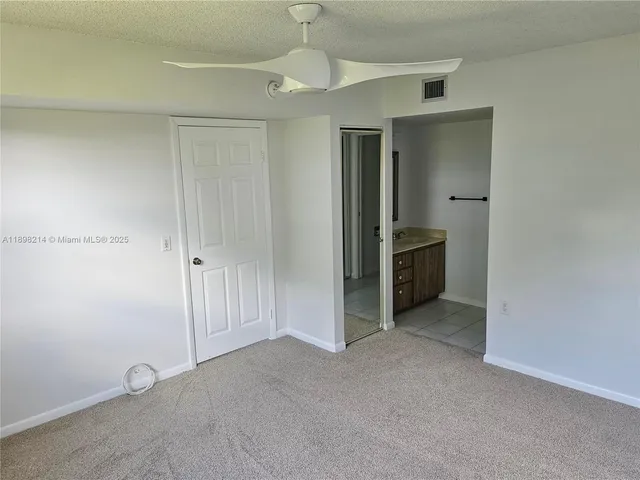 an empty room with closet and windows