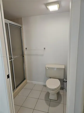 a white toilet sitting next to a shower