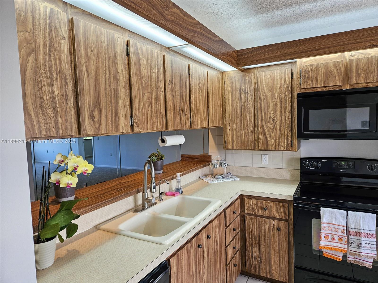6085 Balboa Circle, Unit 403 Boca Raton, FL 33433 - Photo 2 of 32 a kitchen with a sink a stove and cabinets