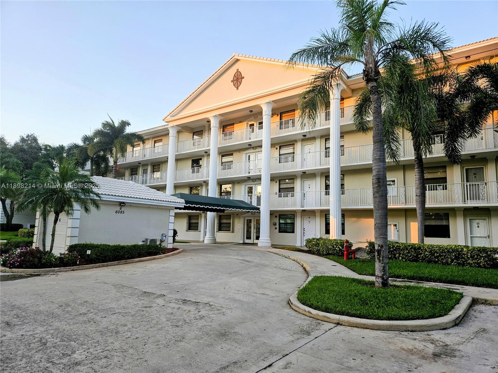 6085 Balboa Circle, Unit 403 Boca Raton, FL 33433 - Photo 27 of 32 a front view of a building with a garden