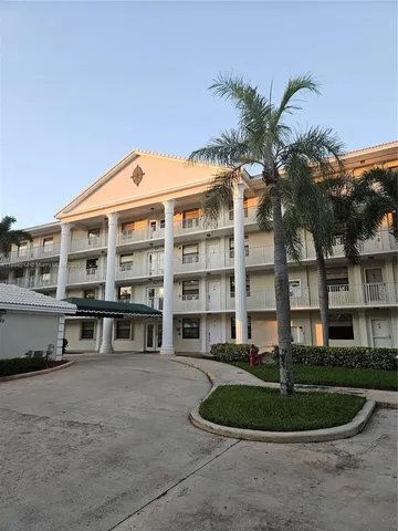 a front view of a building with a garden