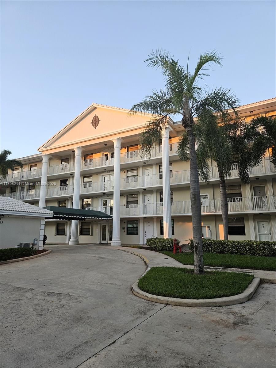 6085 Balboa Circle, Unit 403 Boca Raton, FL 33433 - Photo 28 of 32 a front view of a building with a garden