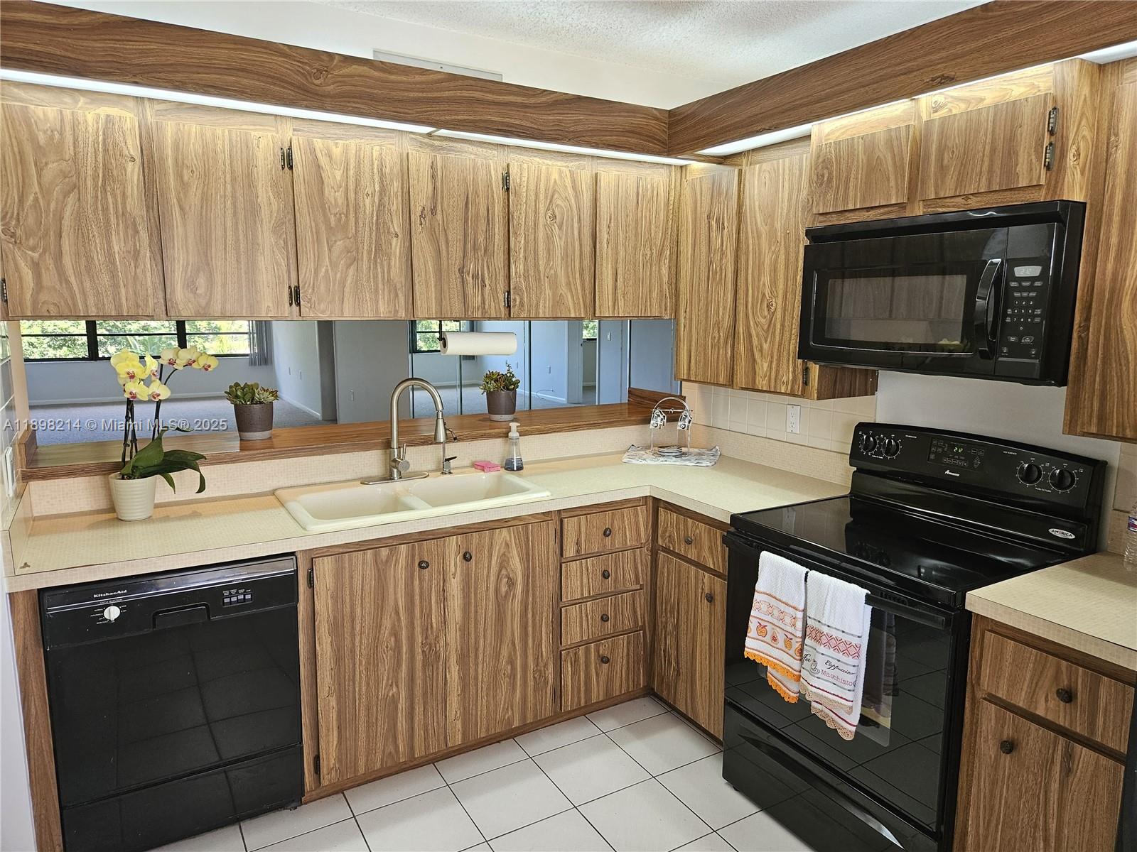 6085 Balboa Circle, Unit 403 Boca Raton, FL 33433 - Photo 4 of 32 a kitchen with a sink stove and microwave