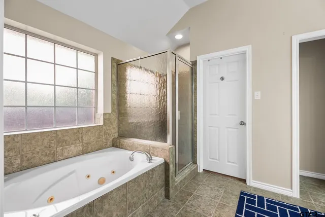 a bathroom with a tub a sink and a shower
