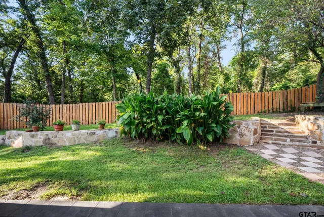 a view of garden with wooden fence