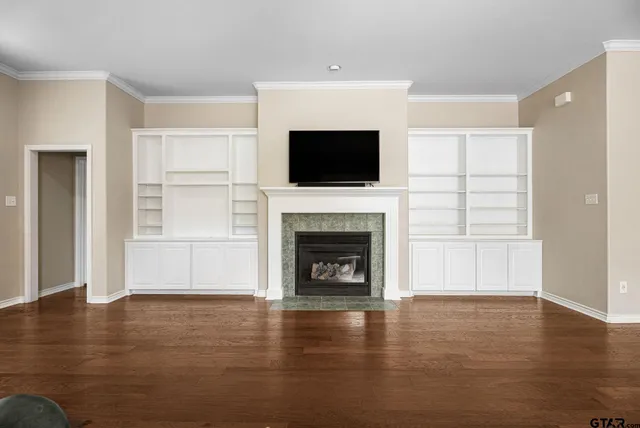 a view of a livingroom with a fireplace wooden floor and window