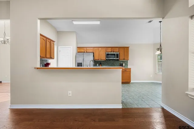 a kitchen with stainless steel appliances granite countertop a refrigerator and a sink