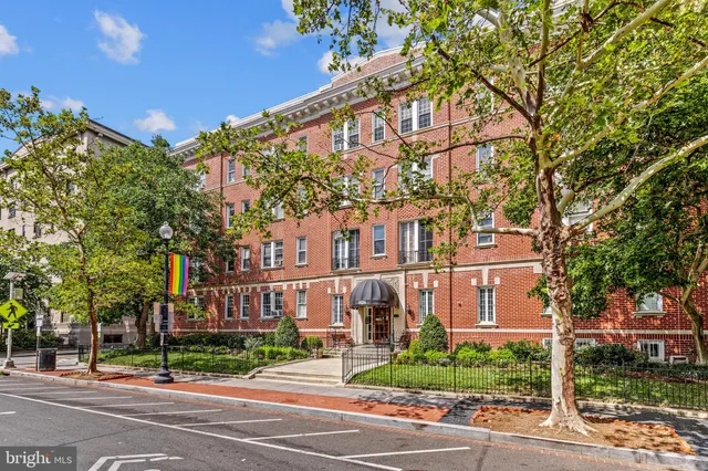a view of a street with a building and trees in the background