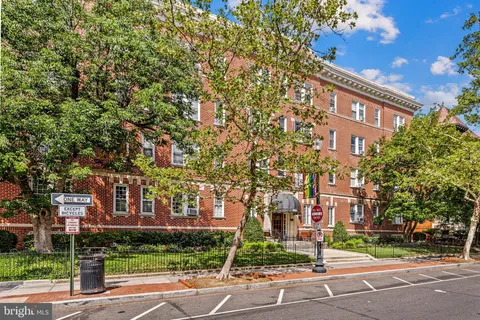 a view of a street with a building and trees in the background