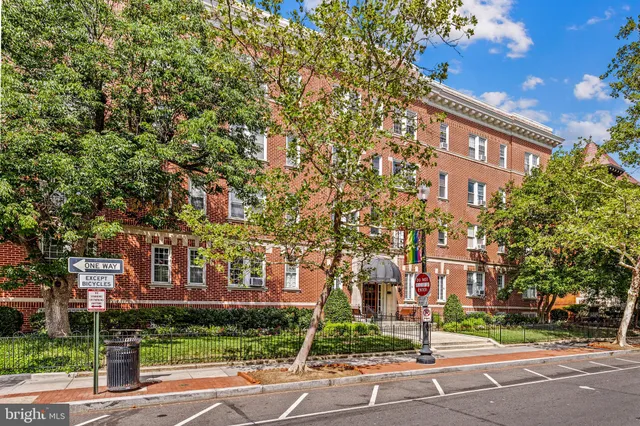 a view of a street with a building and trees in the background