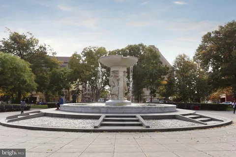 a front view of a building with trees and flowers