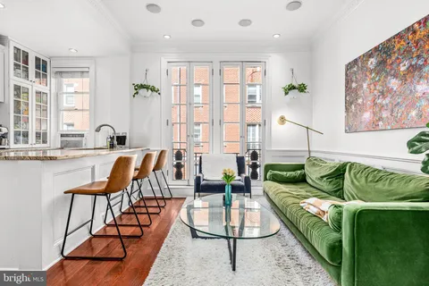 a living room with furniture and floor to ceiling windows