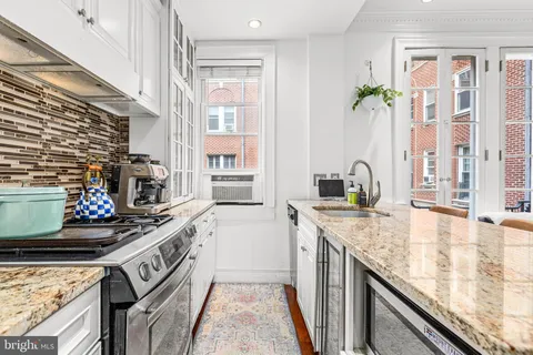 a kitchen with stainless steel appliances granite countertop a sink stove and cabinets