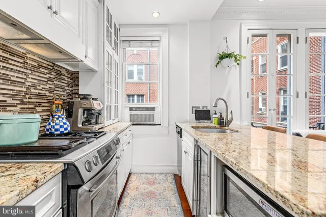 a kitchen with stainless steel appliances granite countertop a sink stove and cabinets