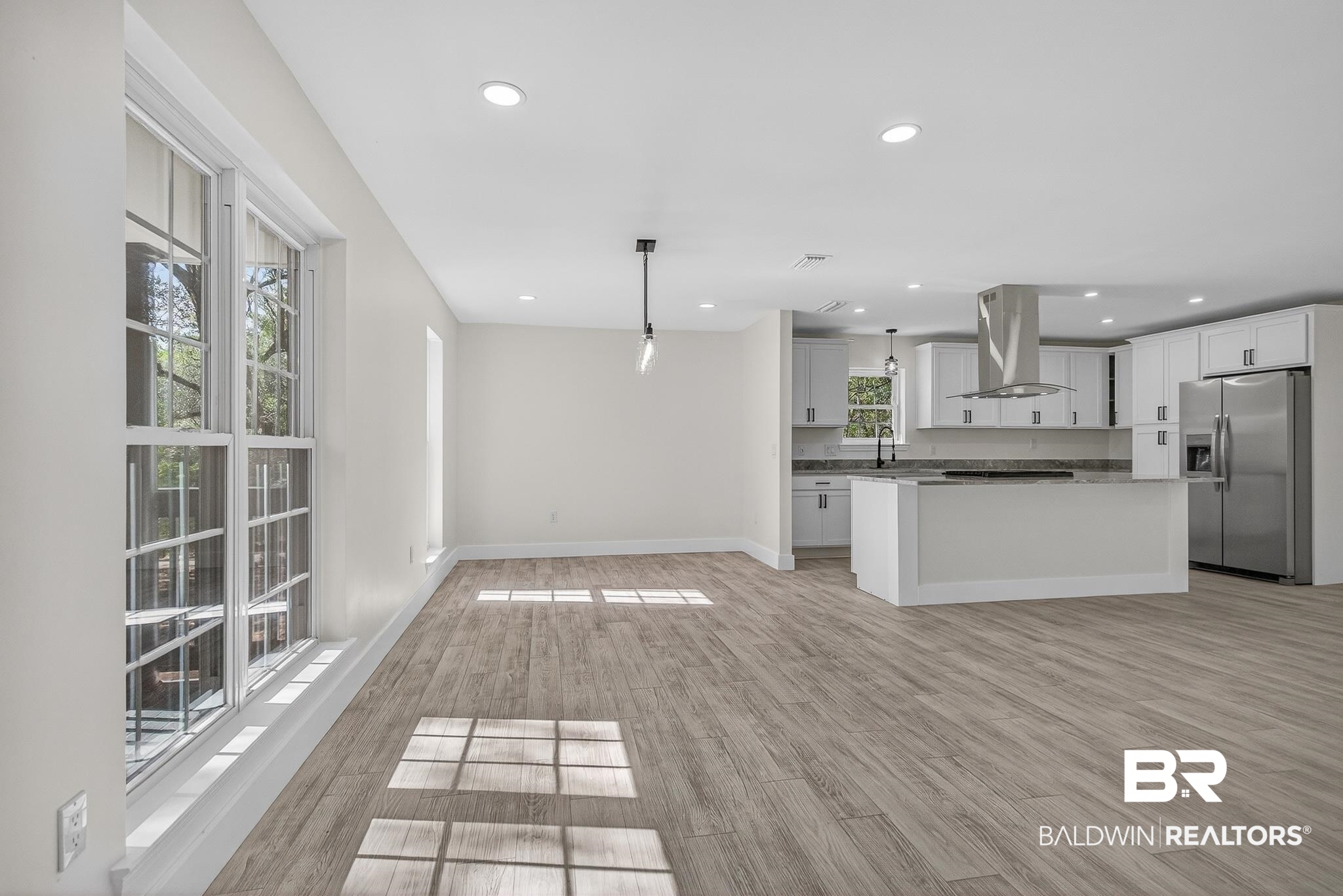 10650 Old Pascagoula Road Theodore, AL 36582 - Photo 13 of 77 Kitchen featuring decorative light fixtures, stainless steel refrigerator with ice dispenser, a center island, light wood-type flooring, and ventilation hood