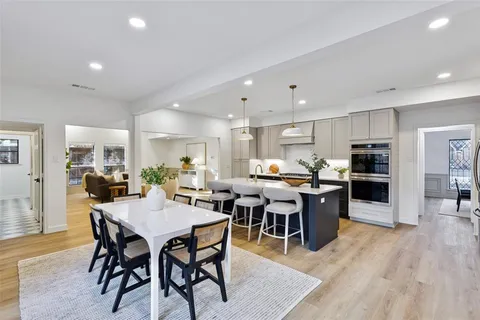 a dining room with stainless steel appliances kitchen island granite countertop a dining table chairs and kitchen view
