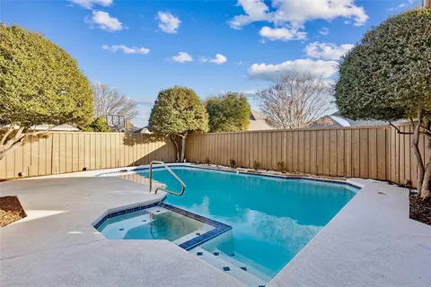 a view of a backyard with a tree and wooden fence