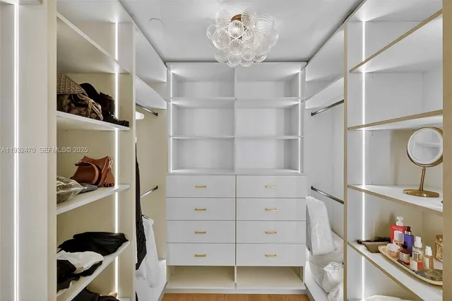 a view of an empty room with closet and wooden floor