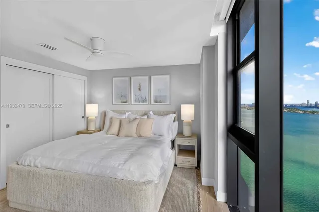 a living room with furniture a potted plant and a large window
