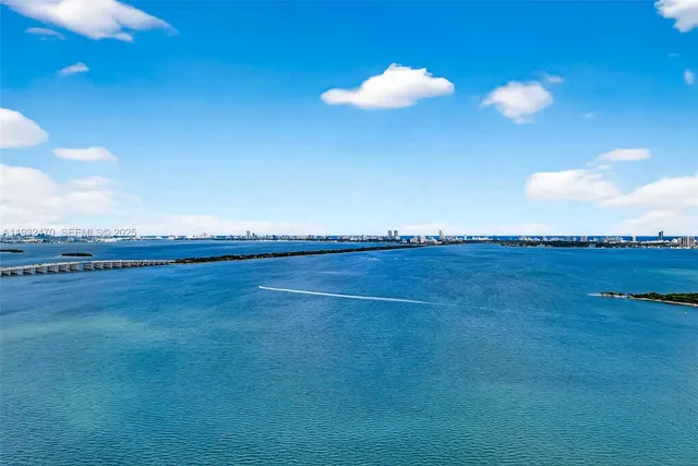 a kitchen with stainless steel appliances granite countertop a sink a counter top space and living room view