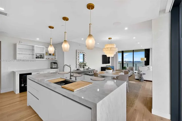 a living room with kitchen island furniture a chandelier and a chandelier
