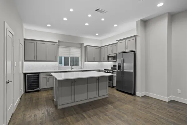 a kitchen with kitchen island a sink stainless steel appliances and cabinets