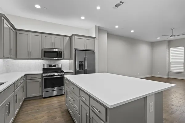 a kitchen with kitchen island a sink stainless steel appliances and cabinets