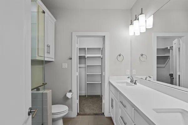 a bathroom with a double vanity sink a toilet and a mirror